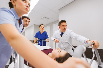 Image showing medics with woman on hospital gurney at emergency