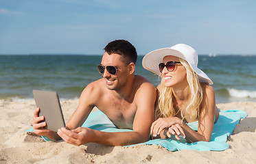 Image showing happy couple with tablet pc sunbathing on beach
