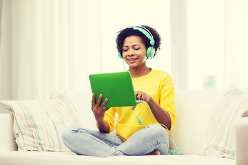 Image showing happy african woman with tablet pc and headphones