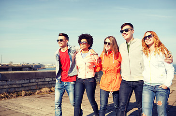 Image showing happy teenage friends walking along city street