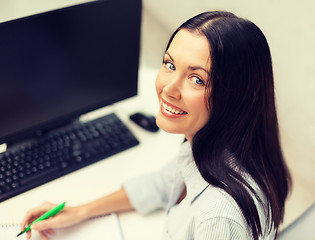 Image showing smiling businesswoman or student studying