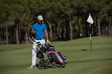 Image showing golf player walking with wheel bag