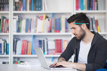 Image showing student in school library using laptop for research