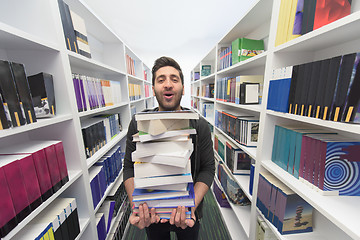 Image showing Student holding lot of books in school library