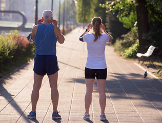 Image showing jogging couple planning running route  and setting music