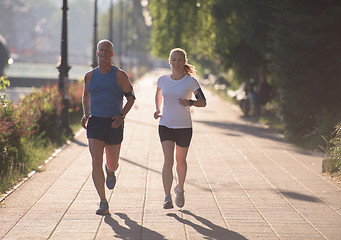 Image showing couple warming up and stretching before jogging