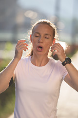 Image showing jogging woman setting phone before jogging