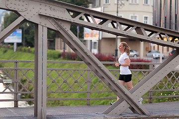 Image showing sporty woman running  on sidewalk