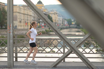 Image showing sporty woman running  on sidewalk