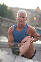 Image showing handsome man stretching before jogging