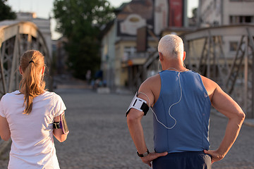 Image showing jogging couple planning running route  and setting music