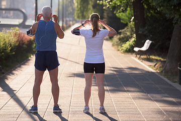 Image showing jogging couple planning running route  and setting music