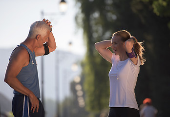 Image showing jogging couple planning running route  and setting music