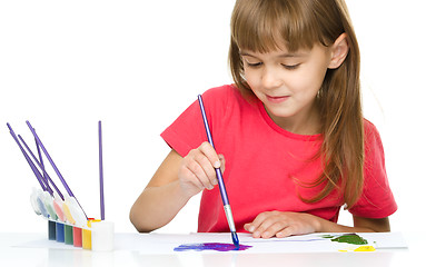 Image showing Little girl is painting with gouache