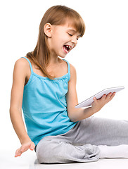 Image showing Young girl is using tablet