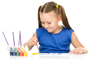 Image showing Little girl is drawing using pencils