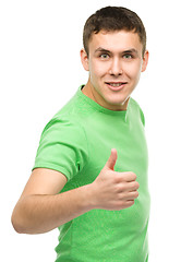 Image showing Cheerful young man showing thumb up sign
