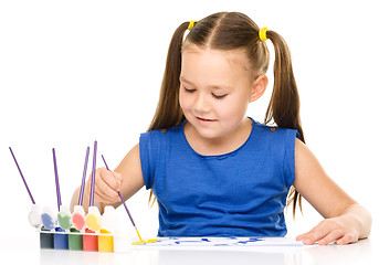 Image showing Little girl is painting with gouache