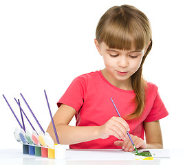 Image showing Little girl is painting with gouache