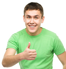 Image showing Cheerful young man showing thumb up sign