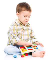 Image showing Little boy is playing with toys