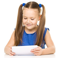 Image showing Young cheerful girl is using tablet