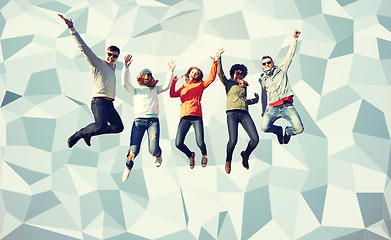 Image showing smiling friends in sunglasses jumping high