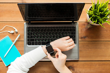 Image showing close up of woman with smart watch and laptop