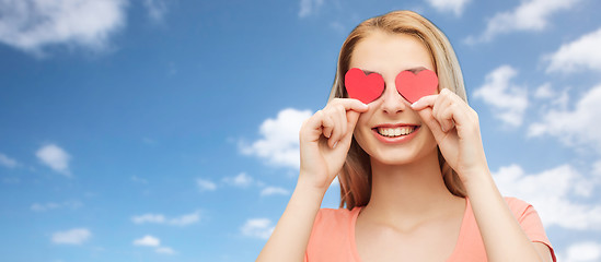 Image showing happy young woman with red heart shapes on eyes