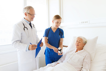 Image showing doctor giving medicine to senior woman at hospital