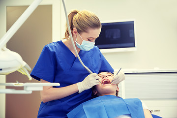 Image showing female dentist checking patient girl teeth