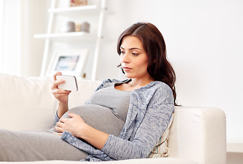 Image showing sad pregnant woman with smartphone at home