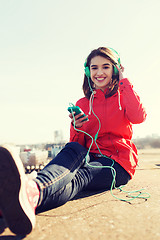 Image showing happy young woman with smartphone and headphones