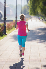 Image showing sporty woman running  on sidewalk