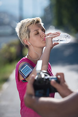 Image showing woman drinking  water after  jogging