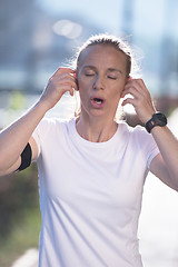 Image showing jogging woman setting phone before jogging