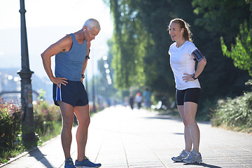 Image showing jogging couple planning running route  and setting music