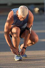 Image showing Man tying running shoes laces