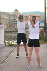 Image showing couple warming up before jogging