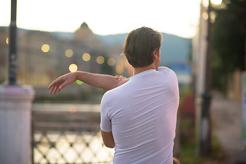 Image showing handsome man stretching before jogging