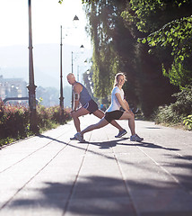 Image showing couple warming up and stretching before jogging