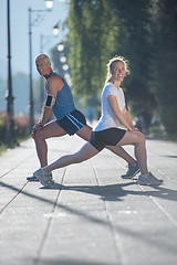 Image showing couple warming up and stretching before jogging