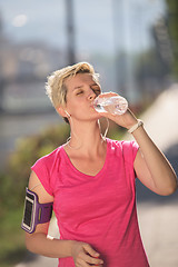 Image showing woman drinking  water after  jogging