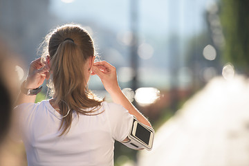 Image showing jogging woman setting phone before jogging