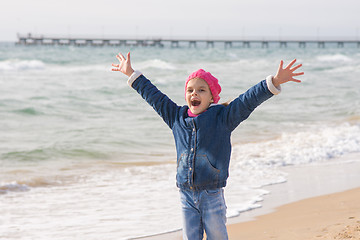 Image showing Seven-year girl rejoices arrival of the sea on the coast in the spring