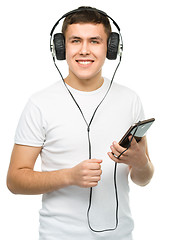 Image showing Young man enjoying music using headphones