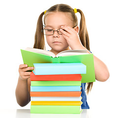 Image showing Little girl is reading a book