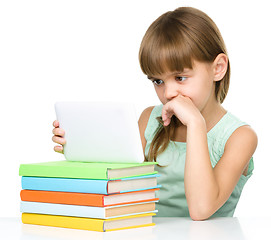 Image showing Young girl is using tablet while studying