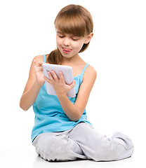 Image showing Young girl is using tablet