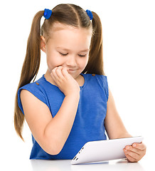 Image showing Young girl is using tablet